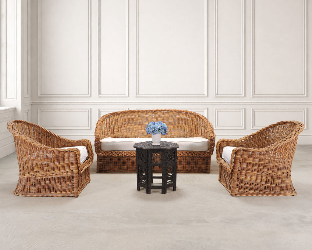 A 3-piece wicker furniture set featuring a curved loveseat, two matching armchairs with white cushions.